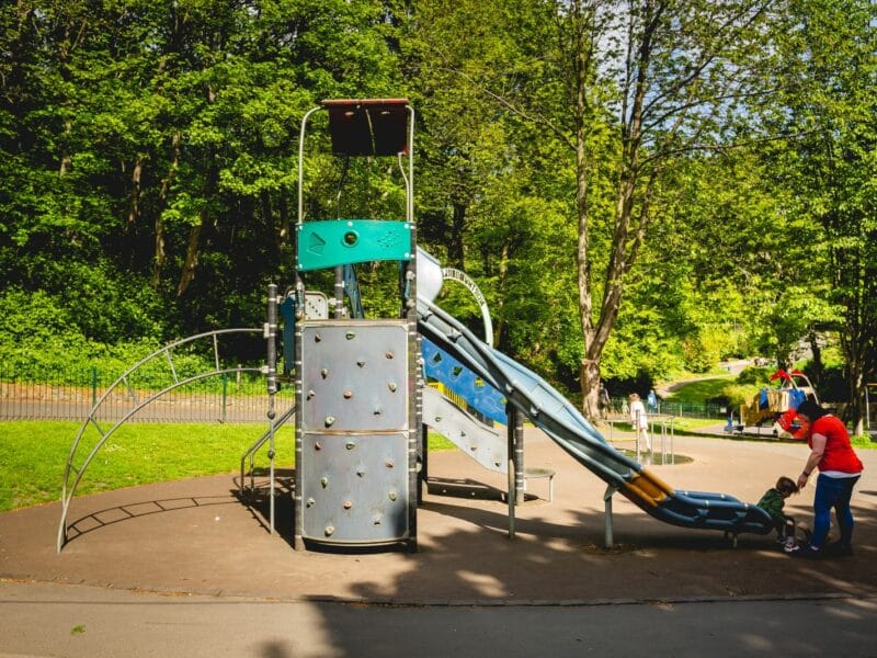 Child and parent at bottom of slide on playground equipment